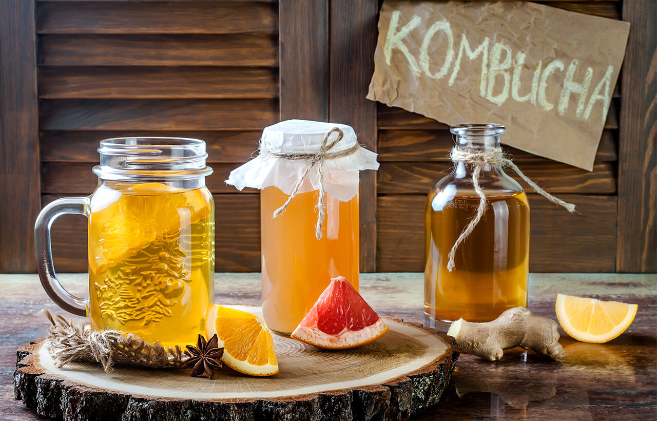 3 kombuchas na mesa: bebidas probióticas de laranja, toranja e limão siciliano com gengibre